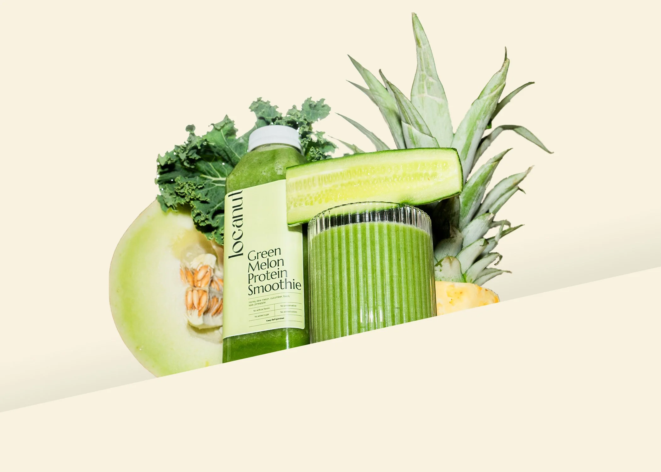 Green smoothie bottle labeled 'Green Melon Protein Smoothie' with kale, honeydew, cucumber, pineapple in background.