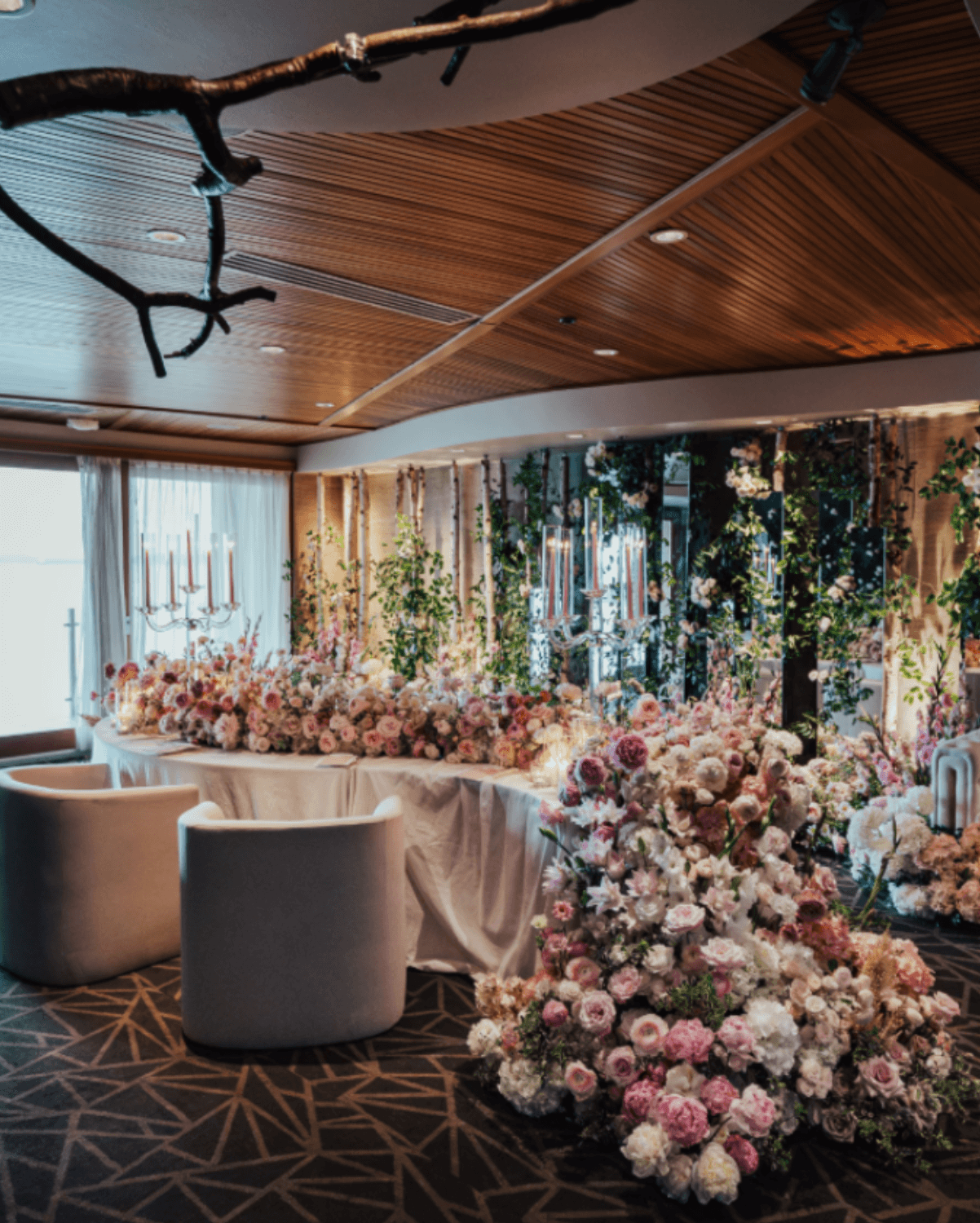 Luxury wedding head table with abundant pink and white floral installations and elegant reception design by Gian Events