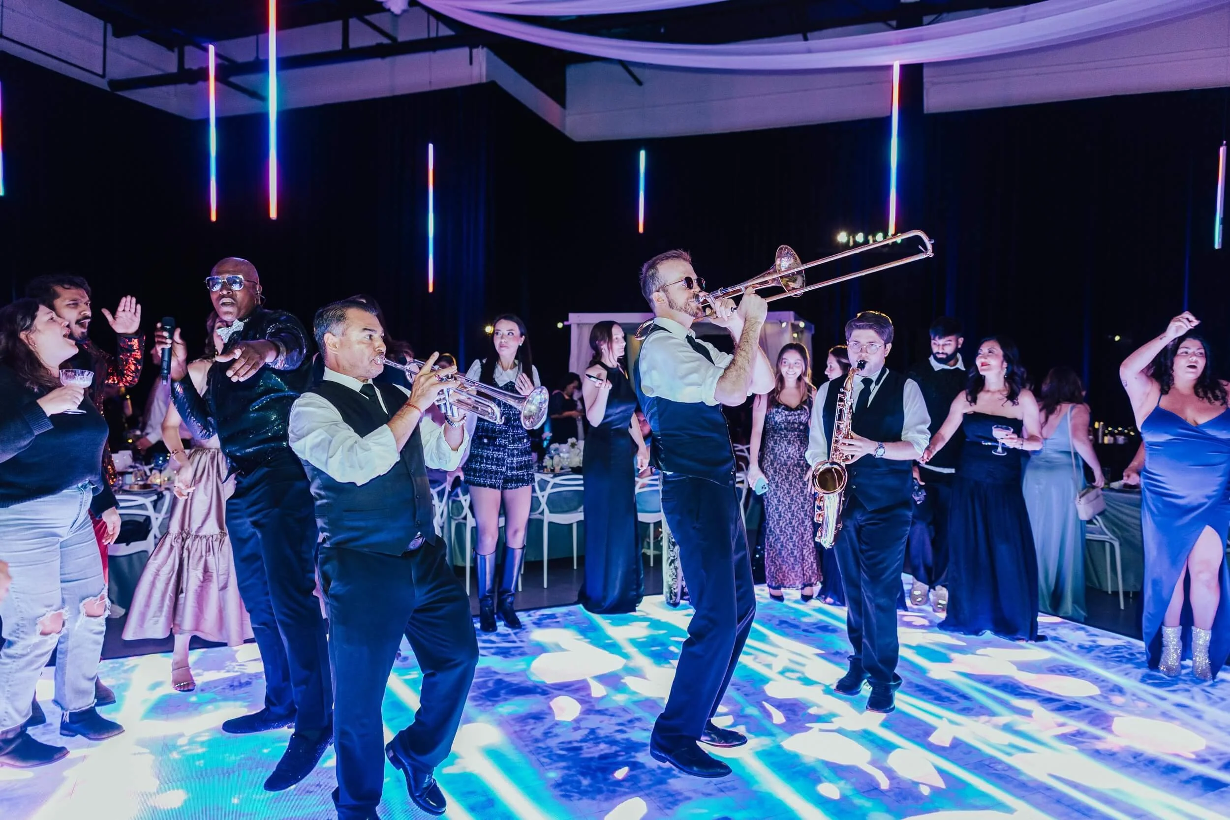 Live band performing at a Gian Events corporate event with guests dancing on a lit dance floor and high-energy entertainment