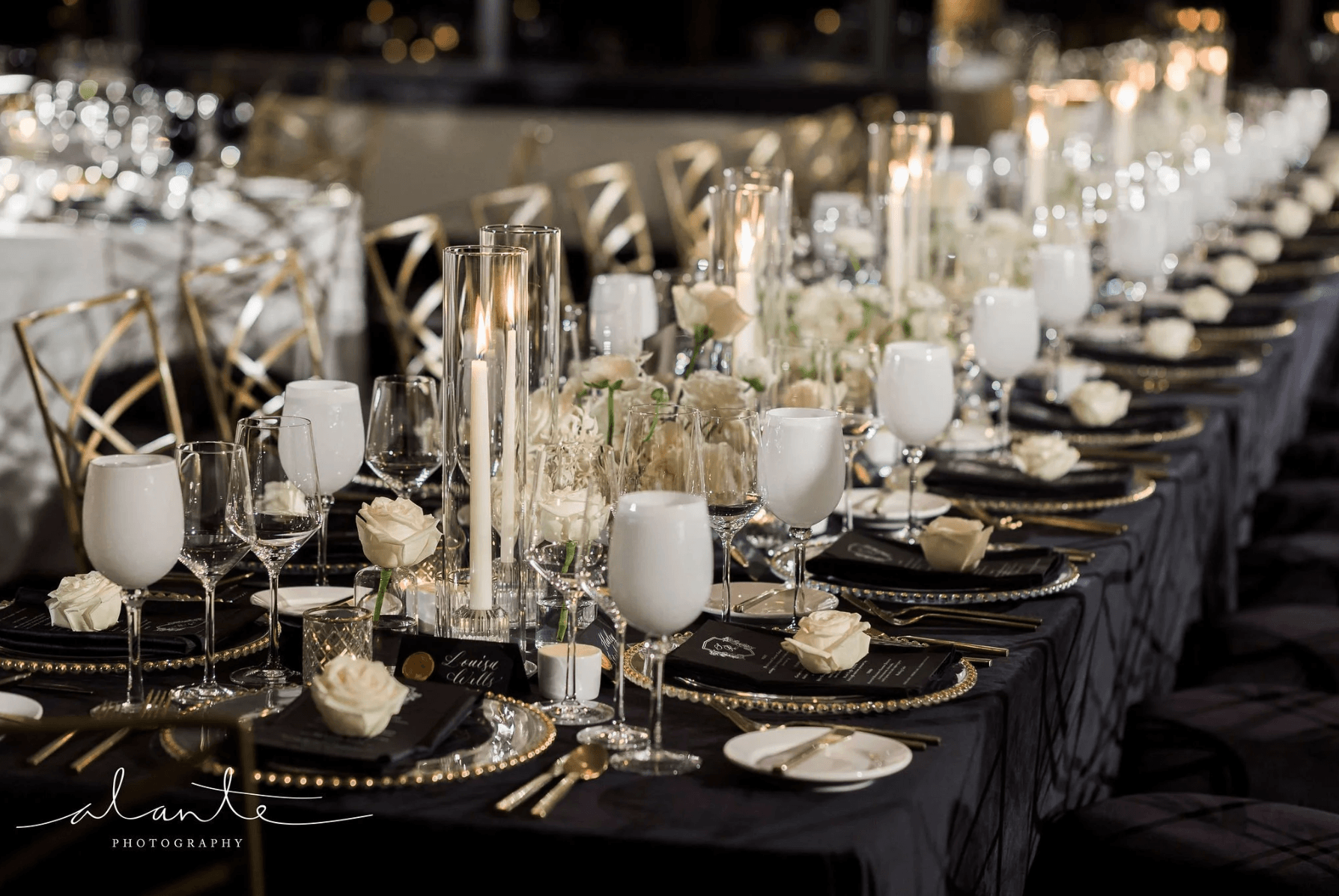 Luxury reception table with black and gold design, candlelight centerpieces, and elegant place settings styled by Gian Events