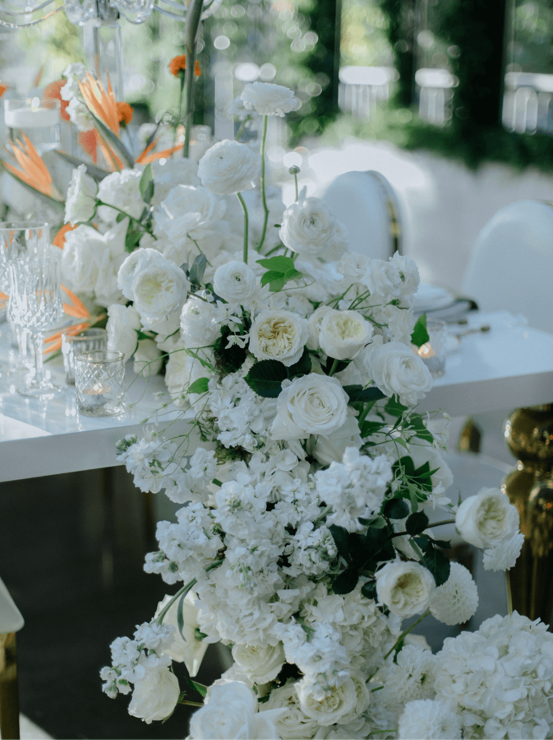 Luxury wedding floral installation with white roses and cascading arrangement on an elegant reception table designed by Gian Events