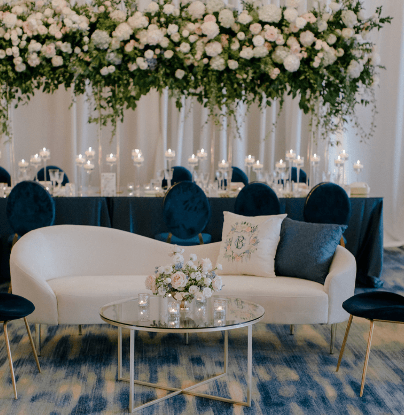 Luxury wedding lounge seating with floral installation and candlelit reception design