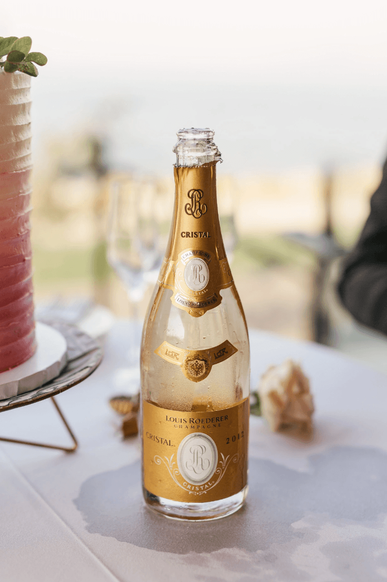 Luxury Cristal champagne bottle at a wedding celebration table representing high-end event experience by Gian Events