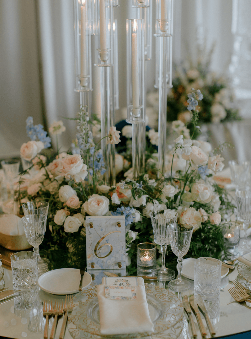 Luxury wedding tablescape with floral centerpiece and tall candle holders in elegant reception design