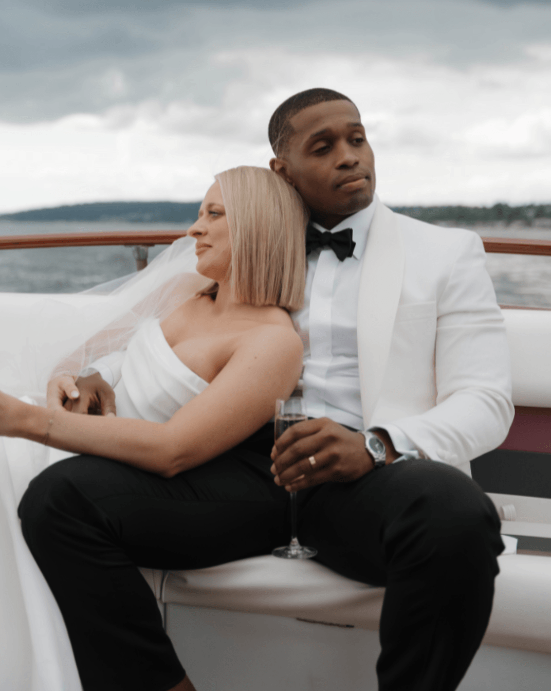 Elegant bride and groom relaxing on a yacht with champagne overlooking the water on their wedding day