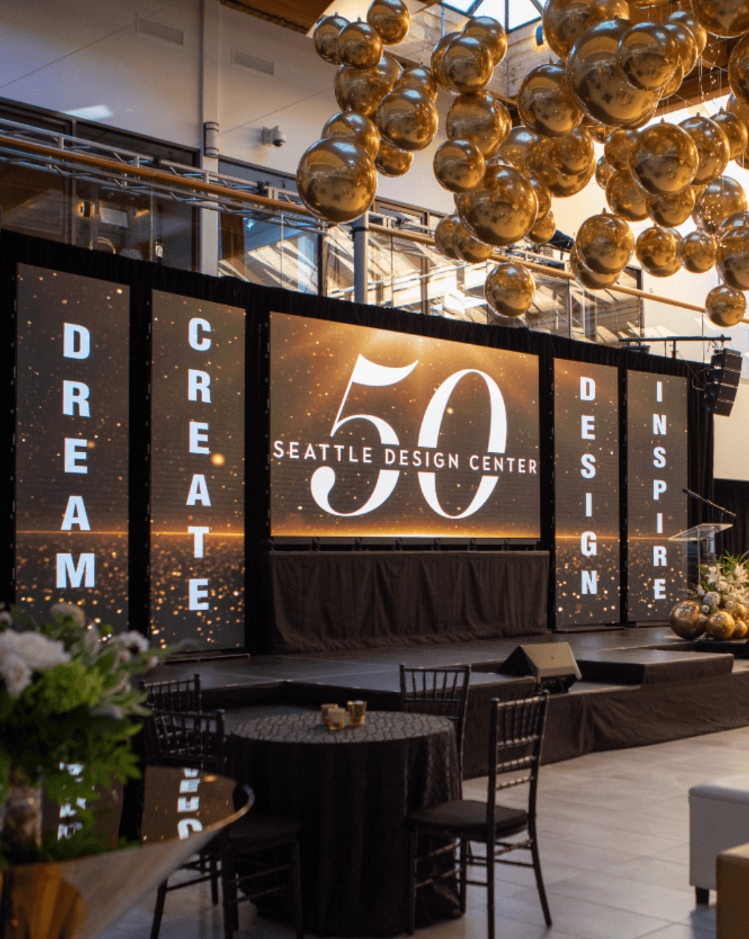 Custom corporate event stage design with branded backdrop at Seattle Design Center celebration