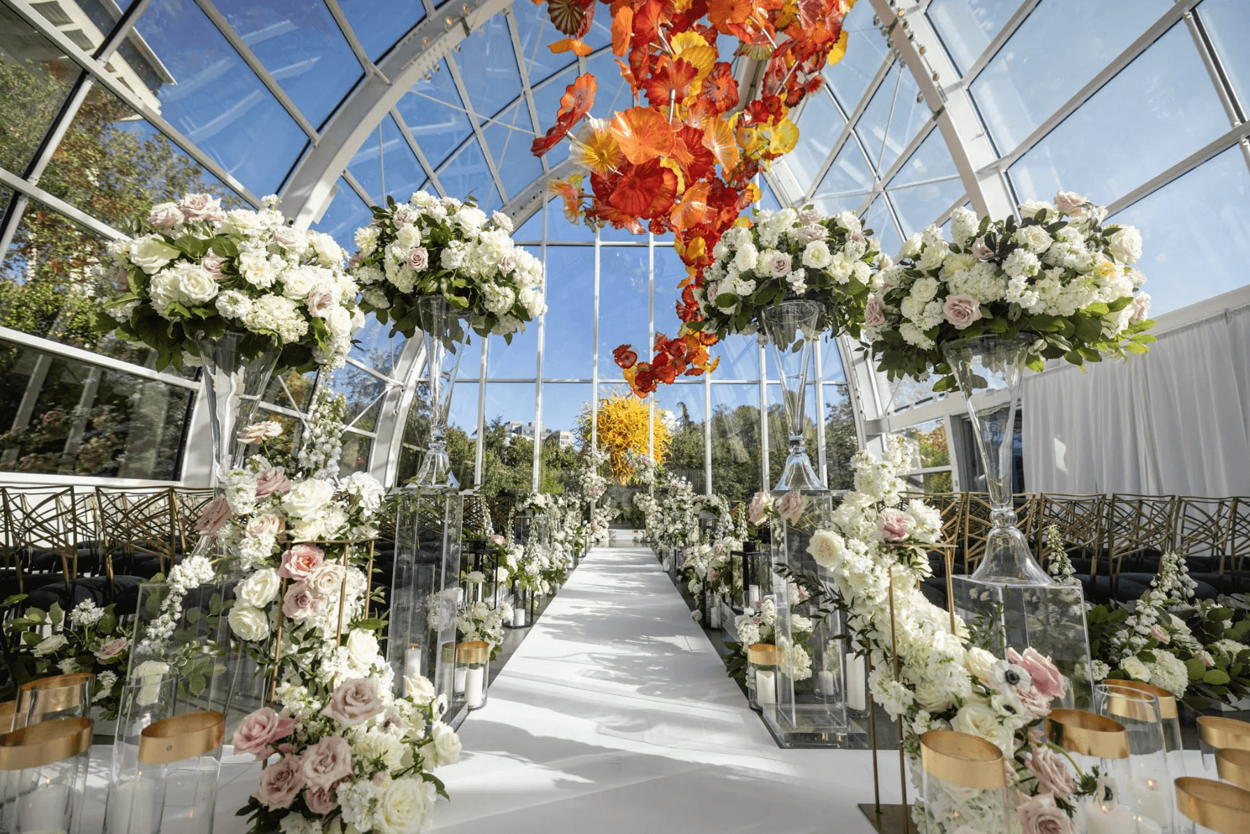 Luxury wedding ceremony aisle with floral installations and glasshouse venue design by Gian Events
