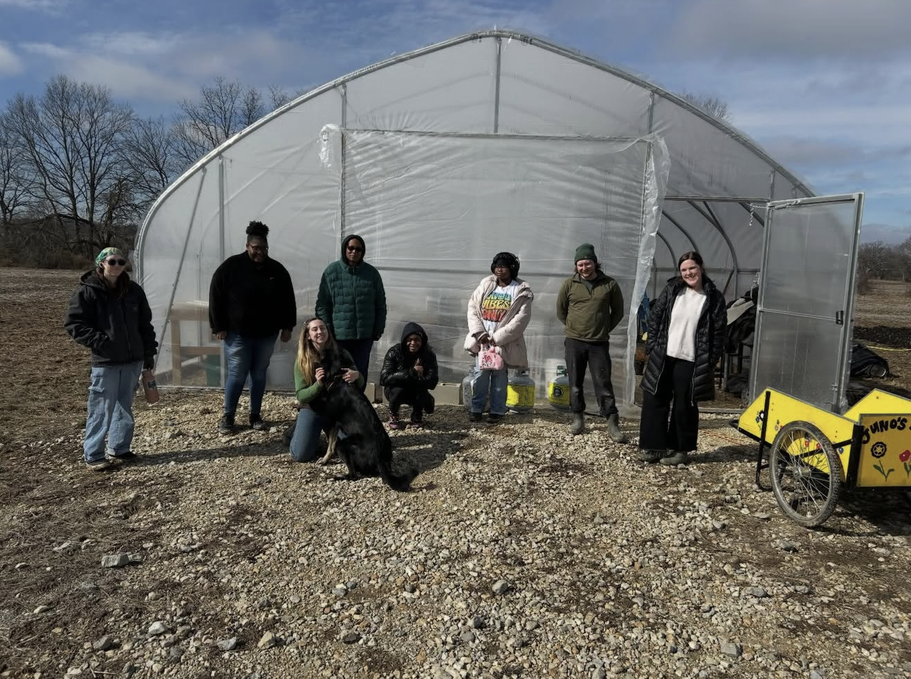 eight students in front of Antioch's greenhouse