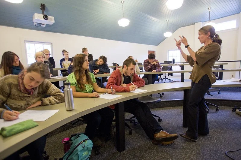 students sitting in a classroom listening to an instructor teaching