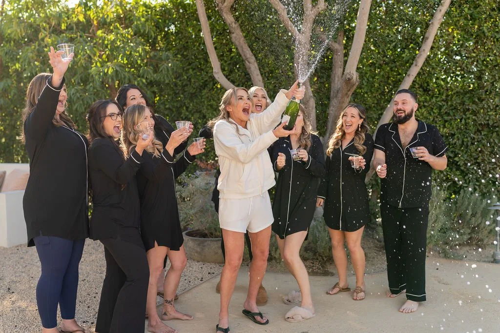 Bridal party popping champagne
