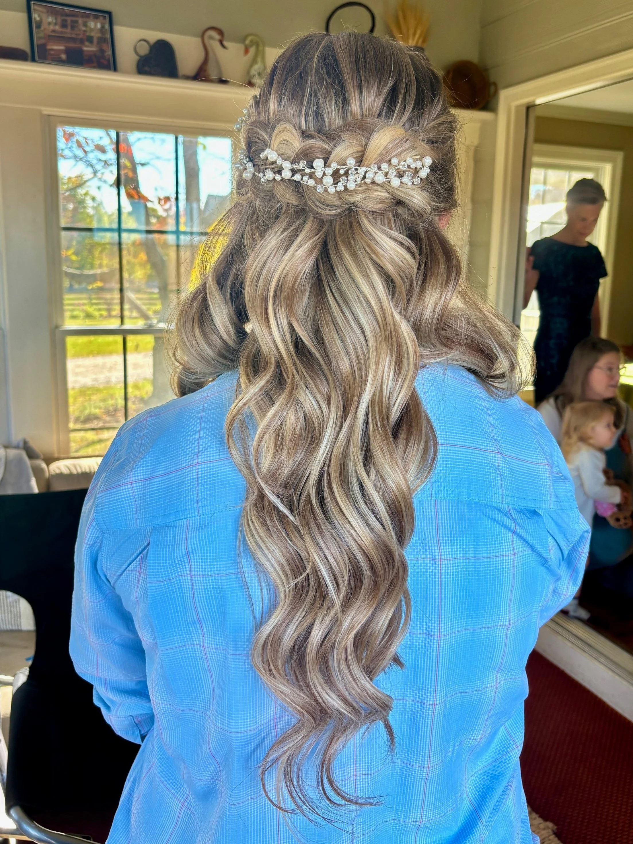 braided half up half down hairstyle for a bride with waves designed by Frederick, Maryland hairstylist and makeup artist featuring a fun bridal hair accessory