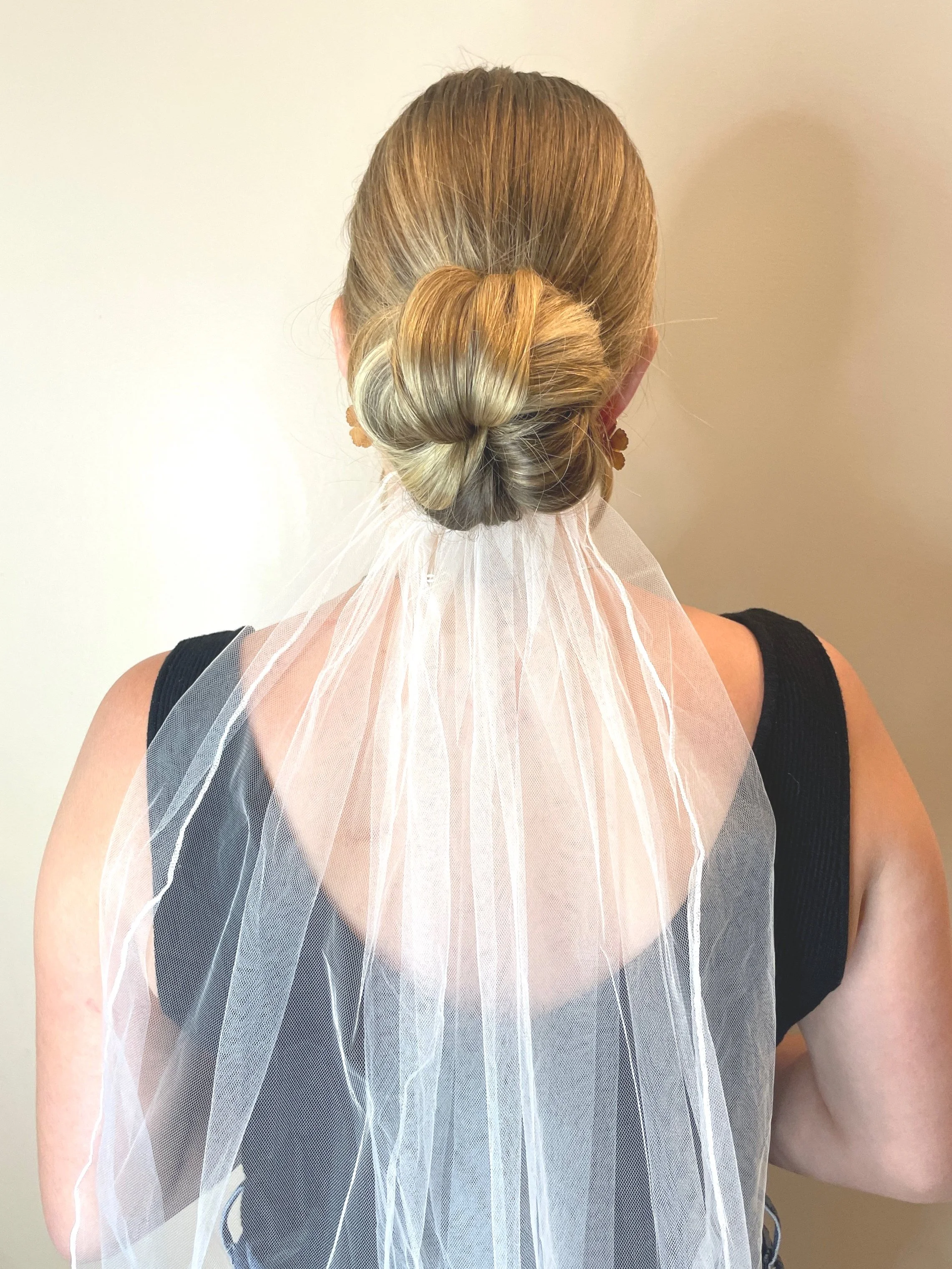 Classic bridal bun with veil fastened in place and styled by Maryland's go to hair stylist and makeup artist, Mandy Rollins