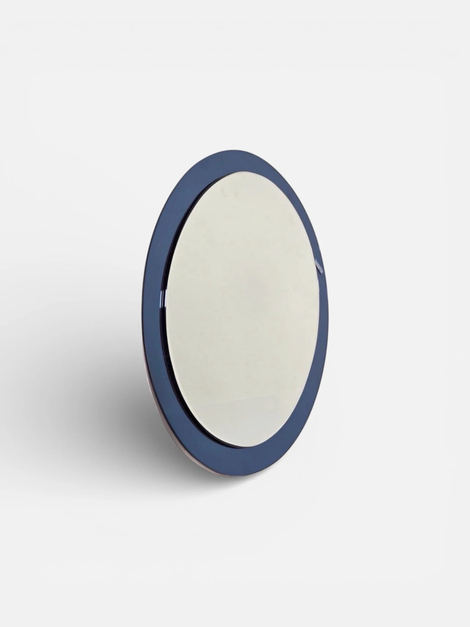 A round mirror with a dark blue frame is shown against a plain white background.