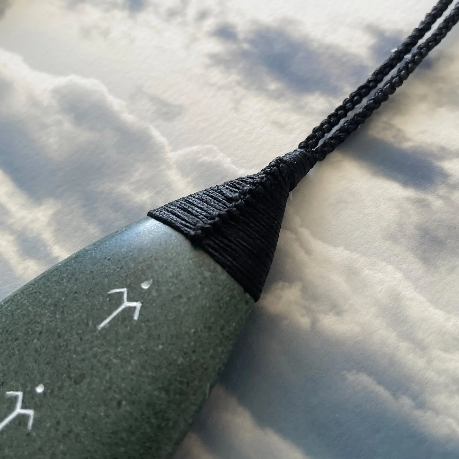 Pounamu surfboard binding up close over Sumner print.