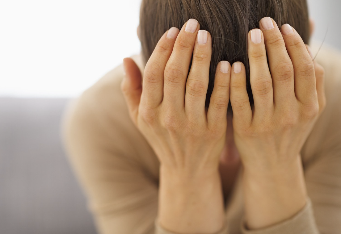 Woman with head in hands showing stress