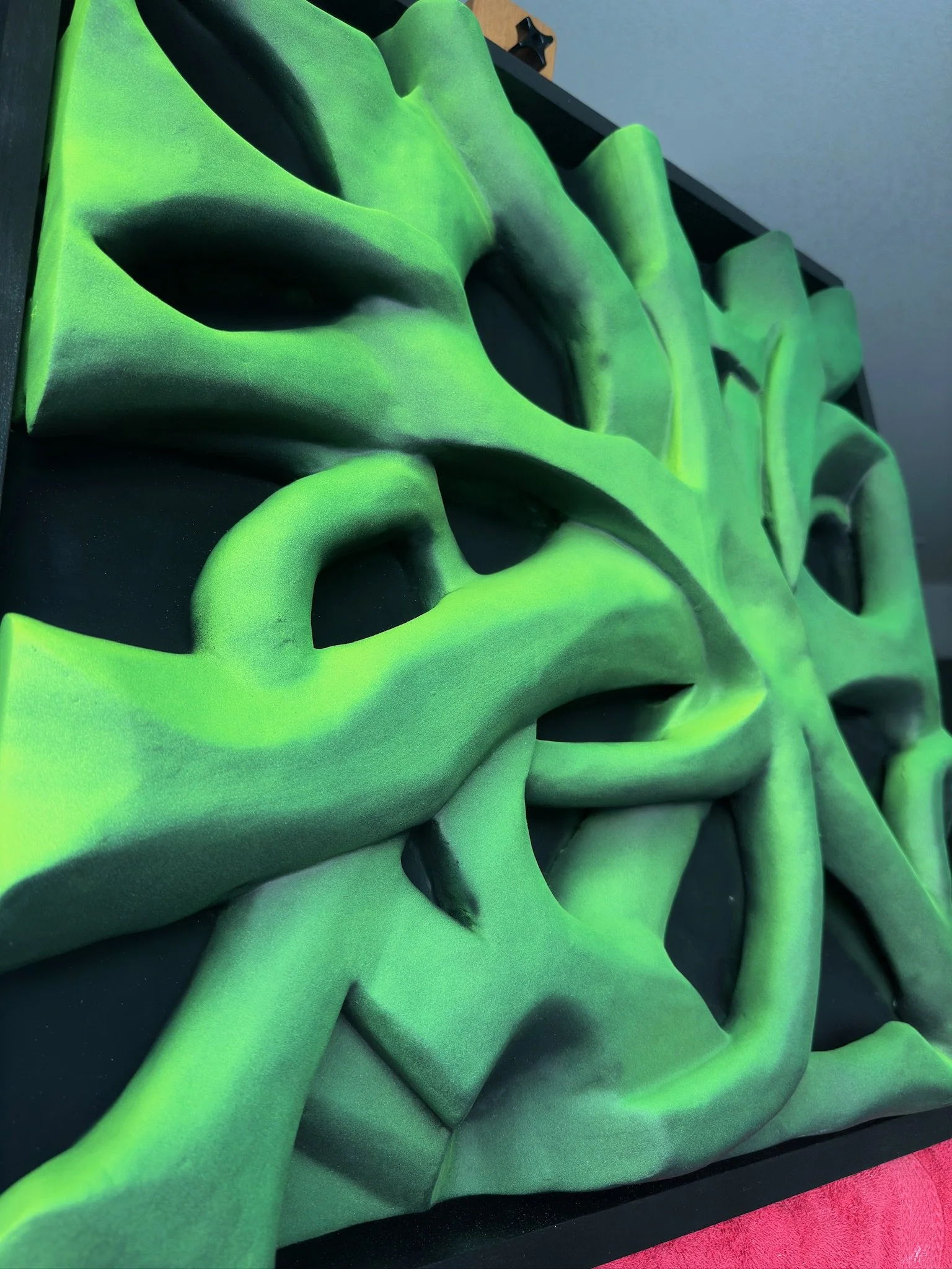 Green branches like sculpture holds with organic shapes and contours.