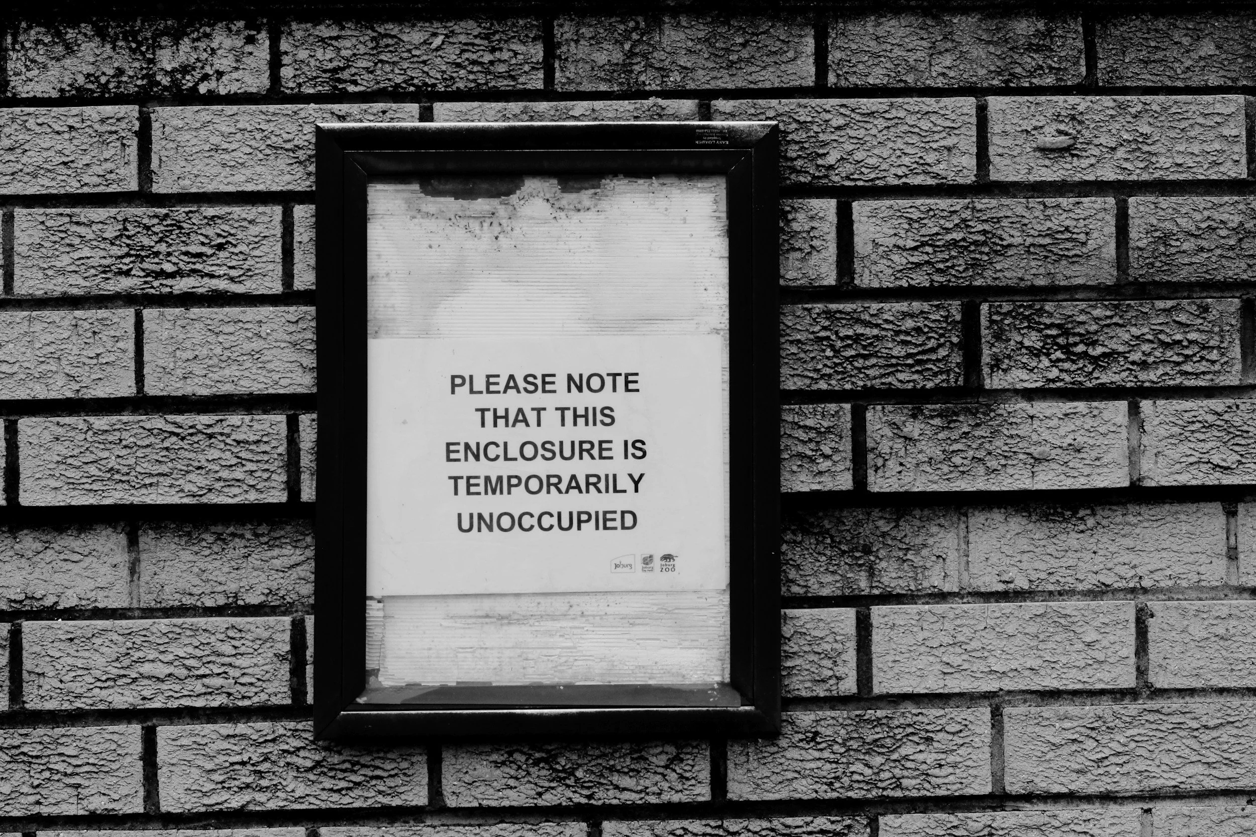 A person sitting indoors with a landscape painting in the background.