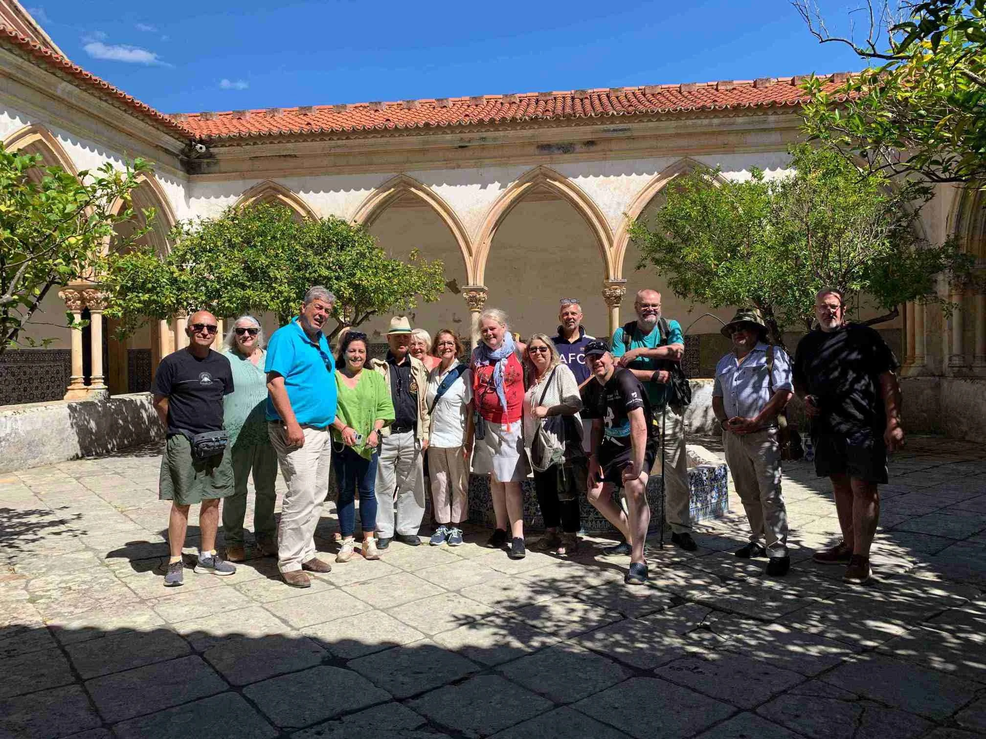 Tourists exploring the cloisters and courtyards of the Convent of Christ in Tomar, Portugal.