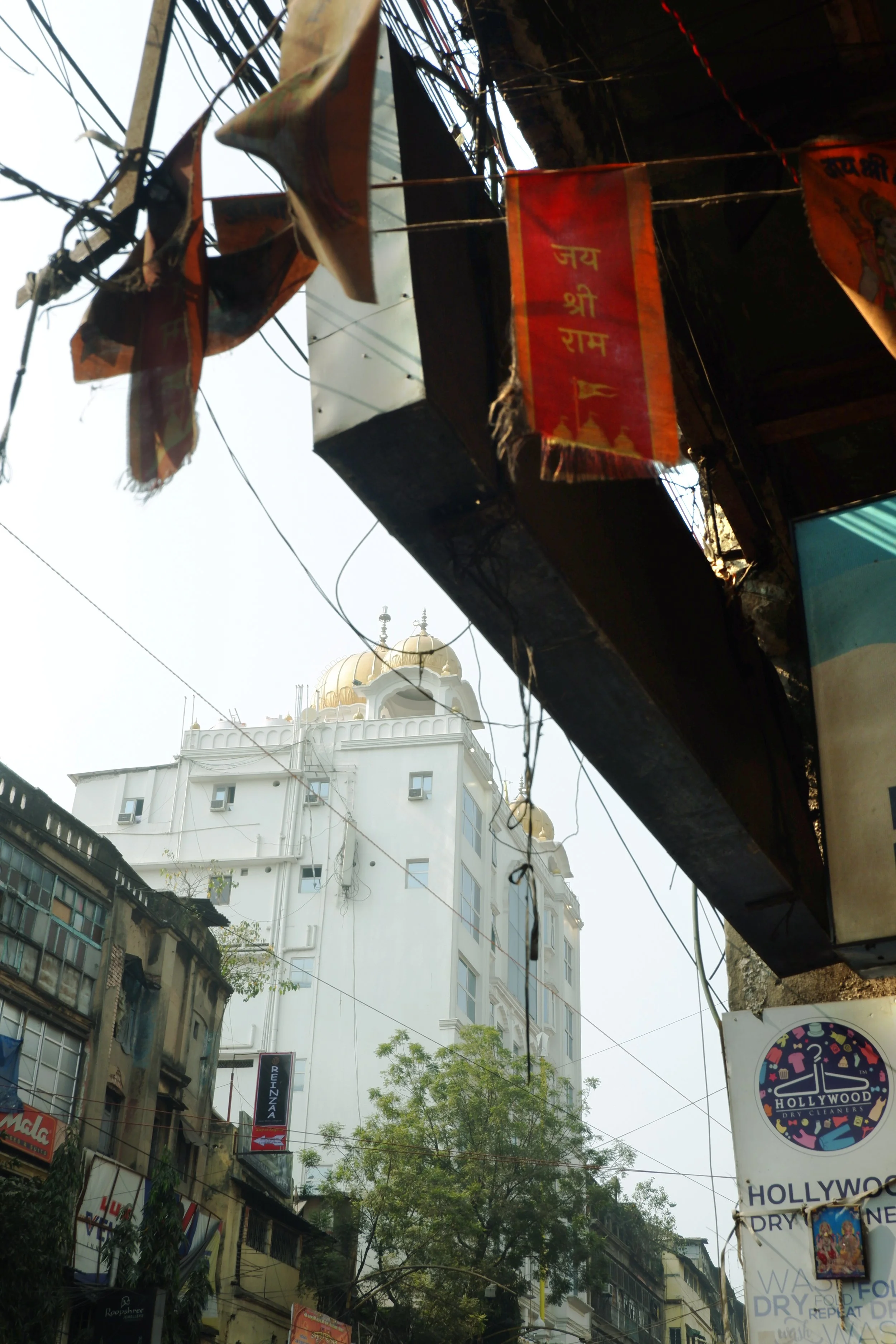 Flags proclaiming "Jai Shree Ram", an identifier of the Hindutva movement, hang on the pavement across from the gurudwara. Conflicting religious spaces are aplenty in the city.