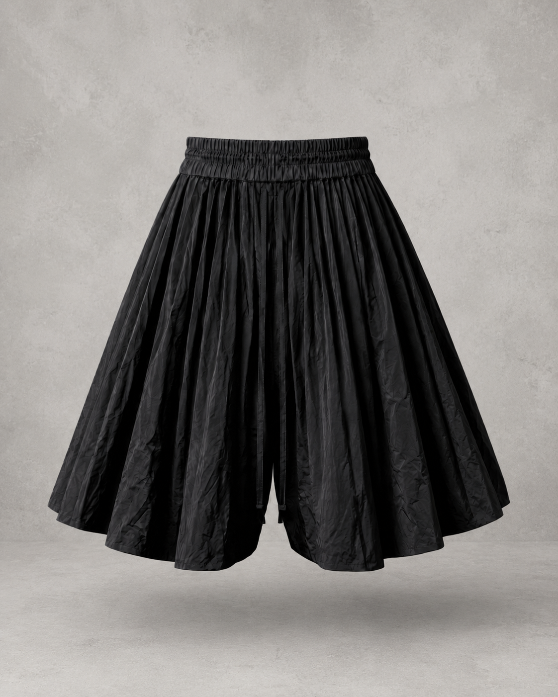 Black pleated midi skirt with an elastic waistband on a plain background.