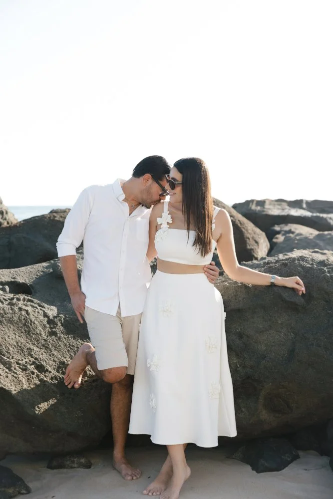 man kissing fiances shoulder during beach engagement photo session