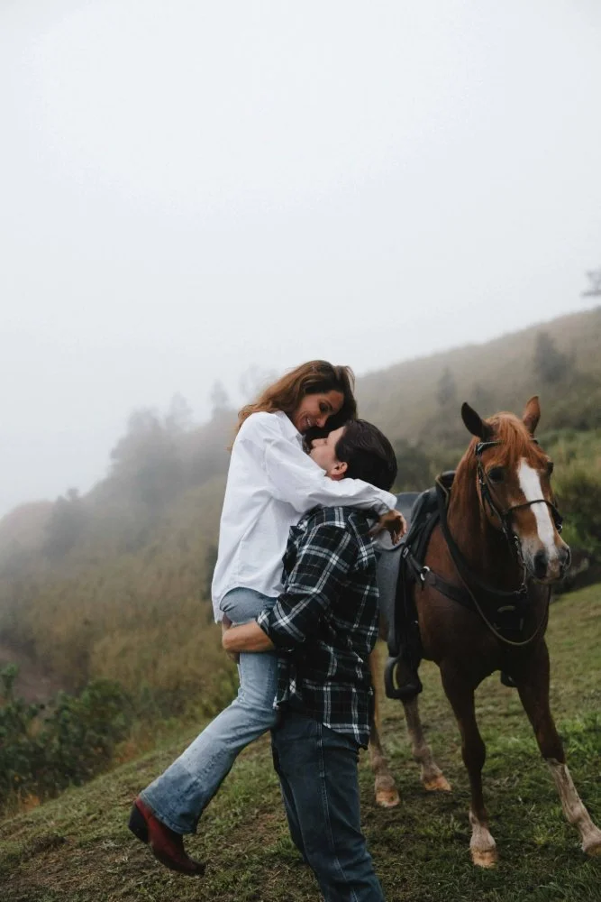 couple smiling at each other in front of a horse in outdoor couples session in puerto rico