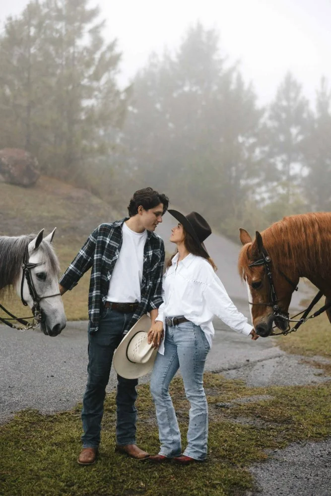 couple gazing at each other in romantic outdoor photo session with horses