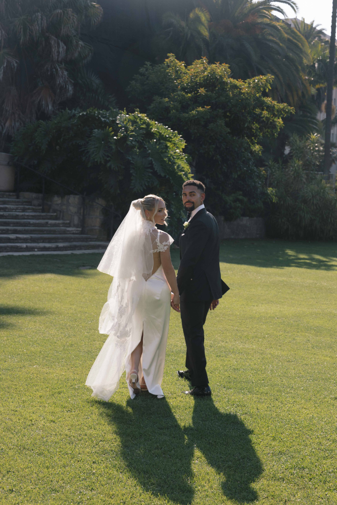 married couple looking back to pose for photo in destination wedding photoshoot in santa barbara