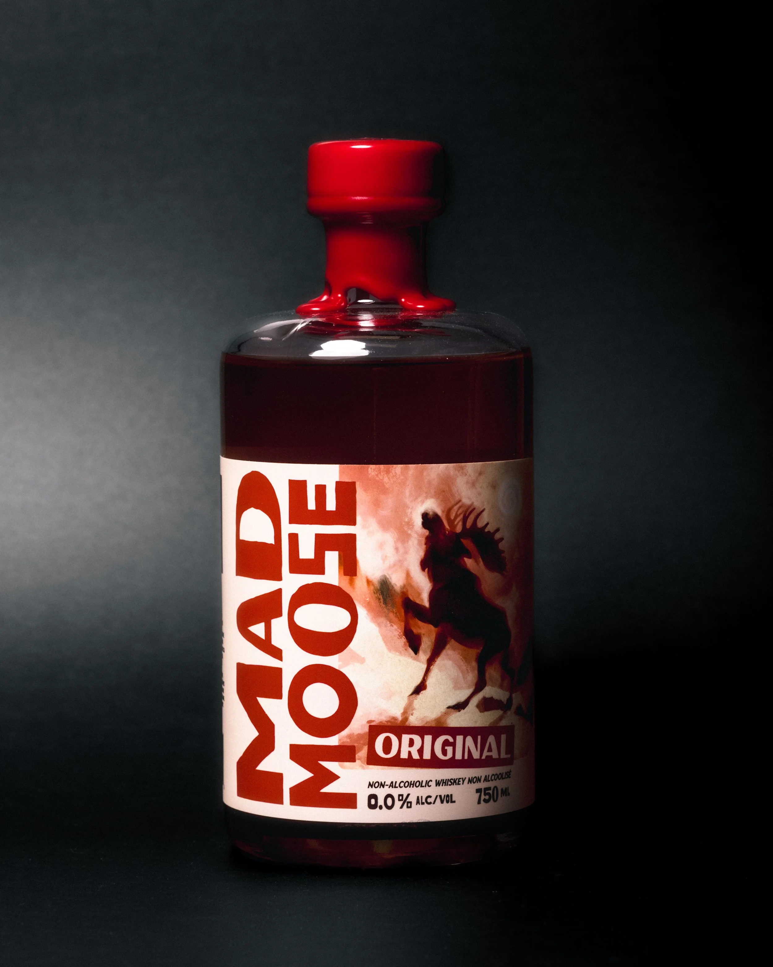 A bottle of non-alcoholic whiskey with a partially visible label showing the bold text Mad MOose and an image of a moose on its hind legs