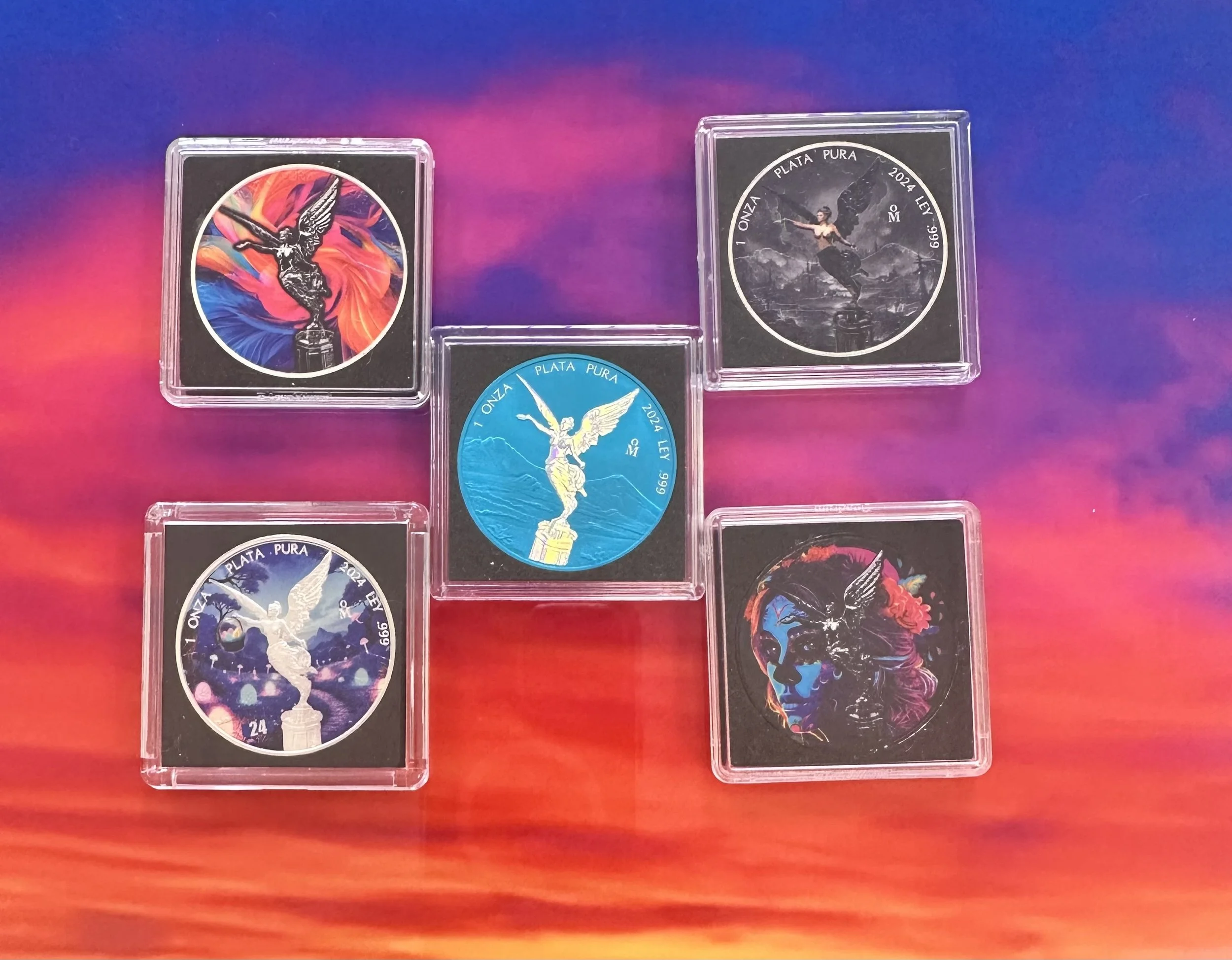 Five collectible coins featuring angelic and artistic designs, displayed in individual plastic cases against a colorful background.
