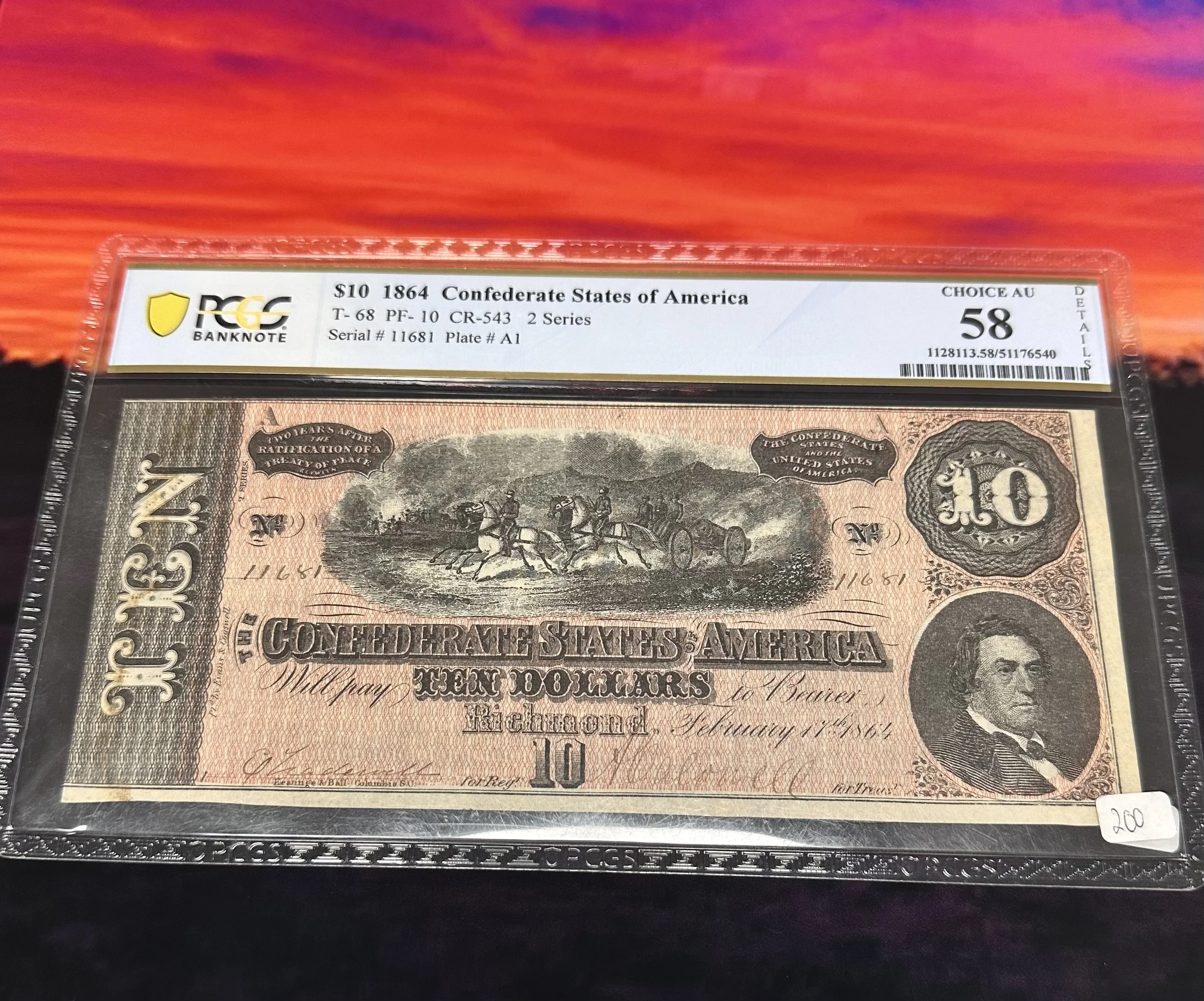 A 10-dollar Confederate States of America banknote from 1864, encased in a protective plastic frame, graded 58 by PCGS, with the label indicating it was minted in Richmond and features a portrait of Jefferson Davis.