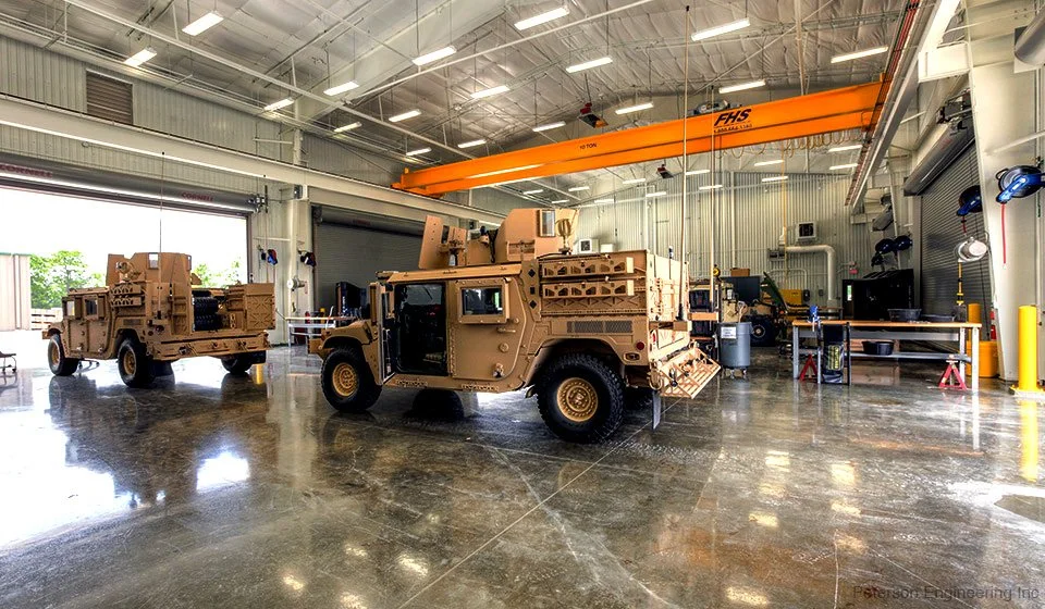 Inside an industrial building with military humvees