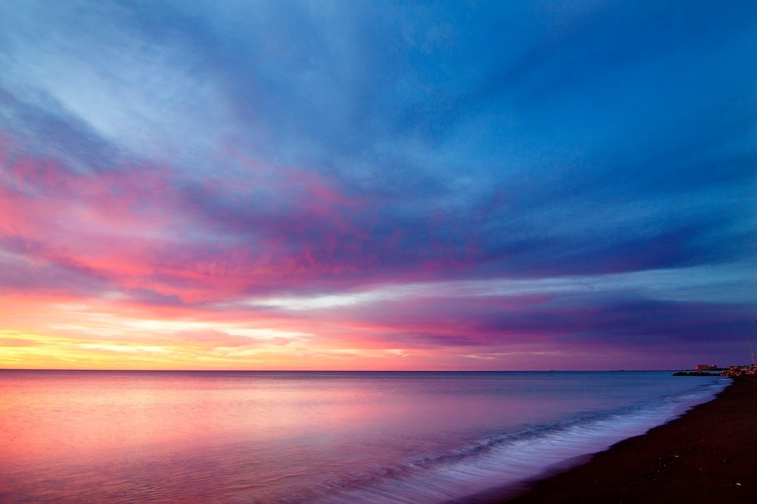 Image linking to the specialization page for emerging adults. The picture shows a colorful sky during a sunrise over a body of water.