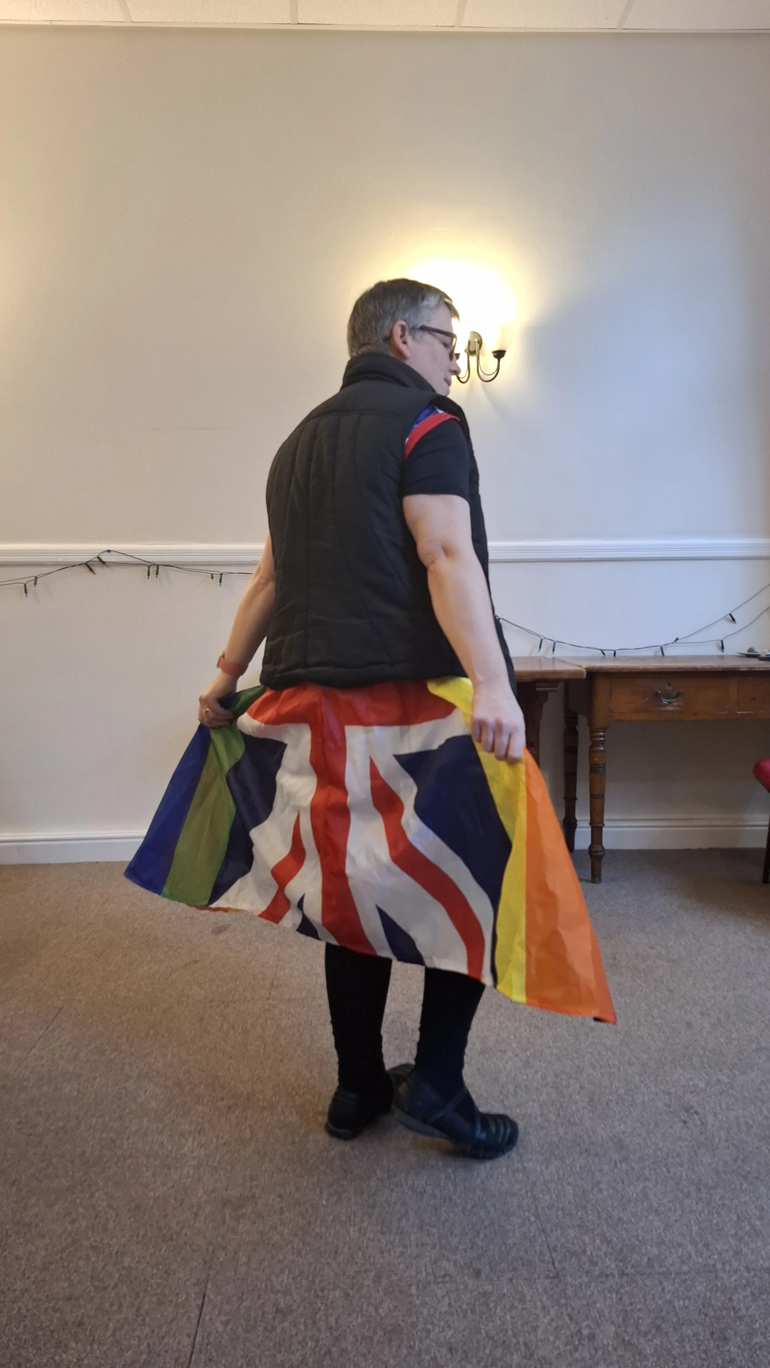 A woman wearing a multi coloured dress made of flags