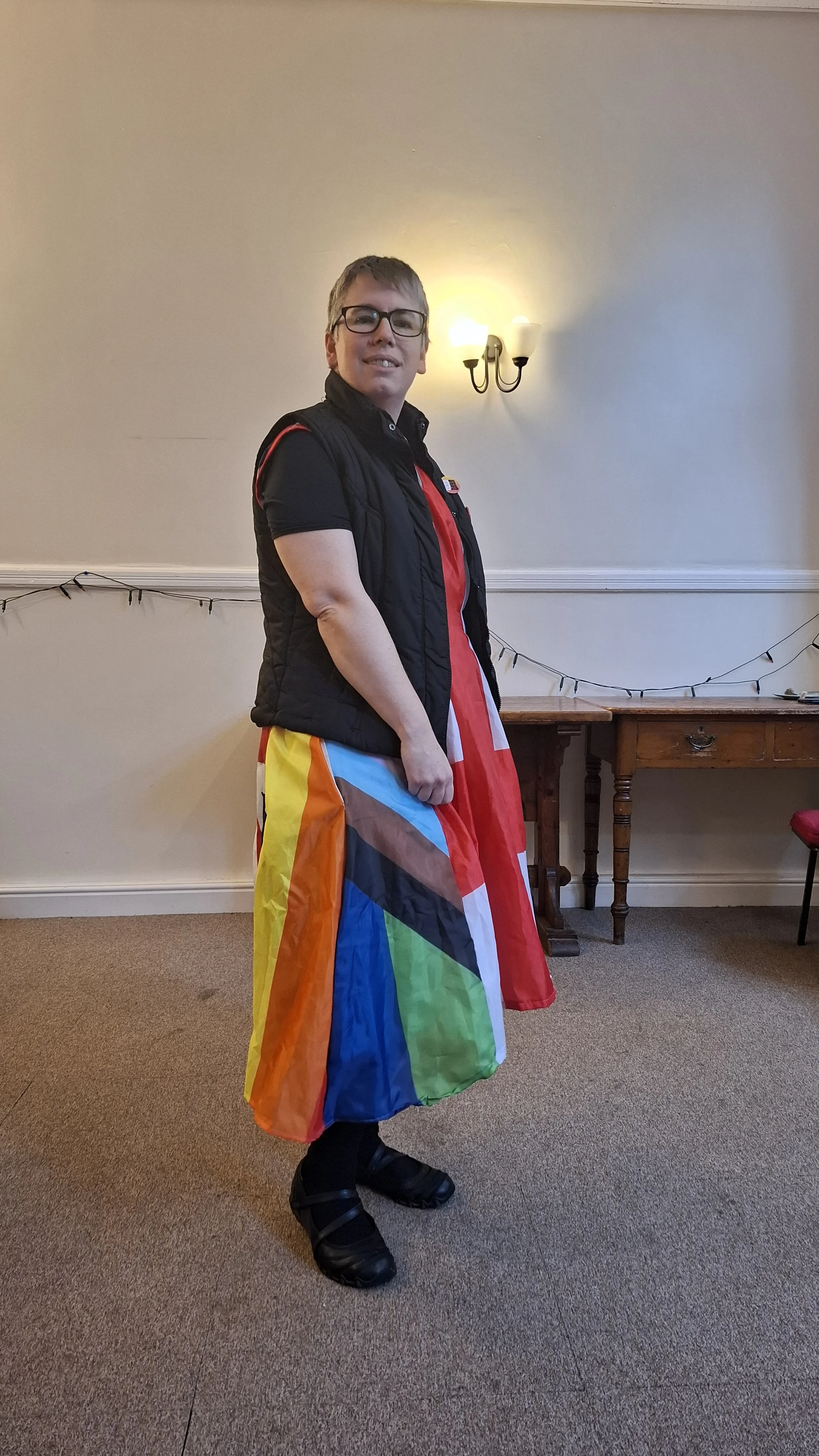 A woman wearing a multi coloured dress made of flags