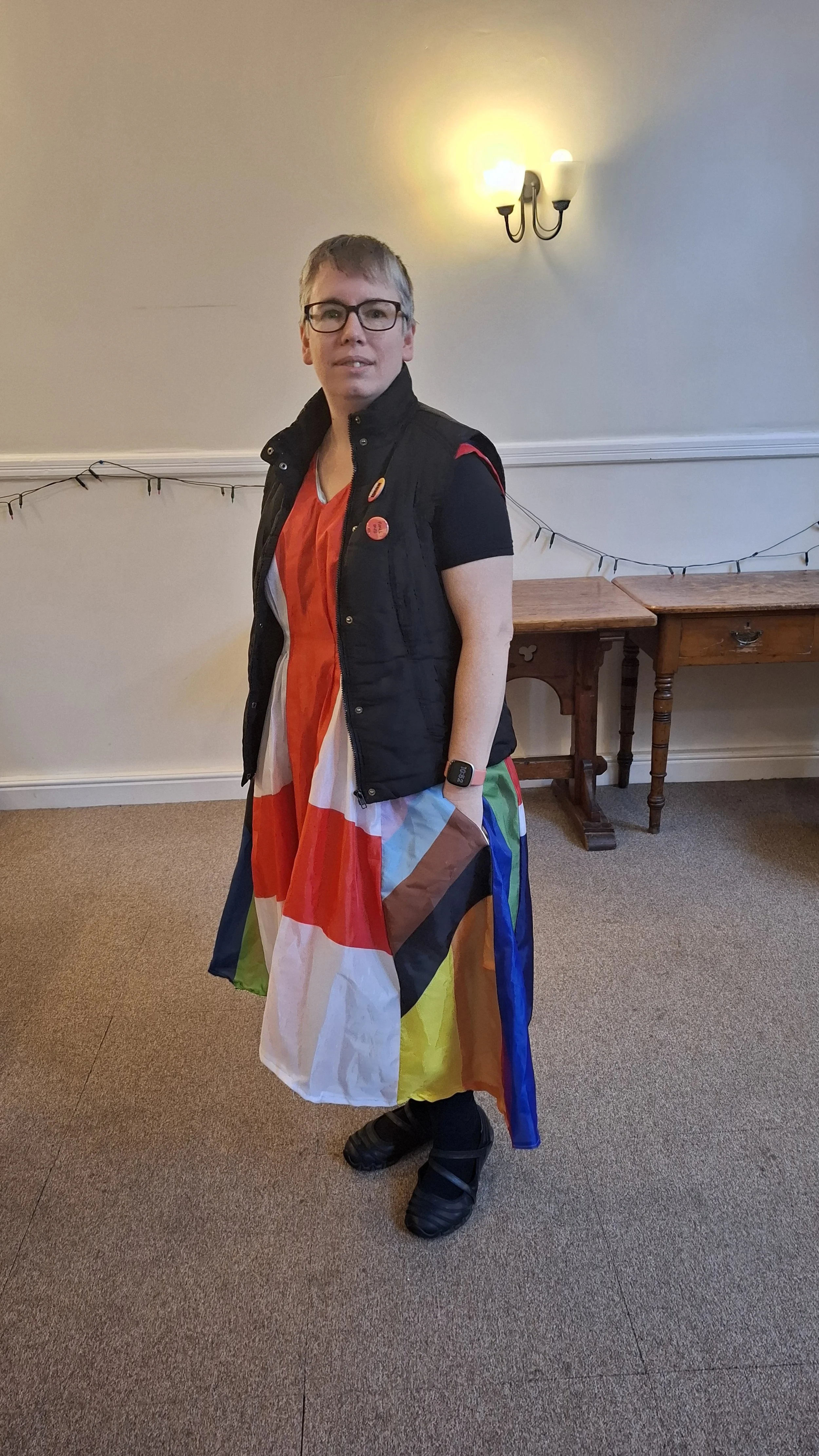 A woman wearing a multi coloured dress made of flags