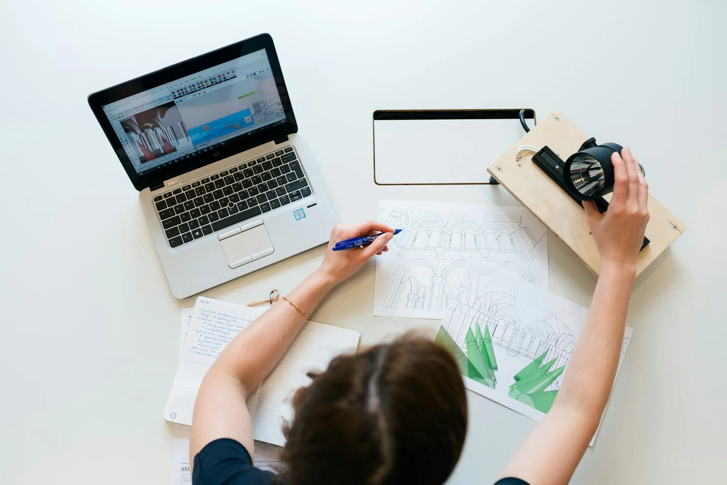 Person planning real estate business at a white desk with a laptop