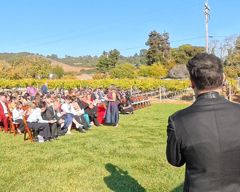 Ant Smith performing live saxophone during an outdoor vineyard wedding ceremony in California.