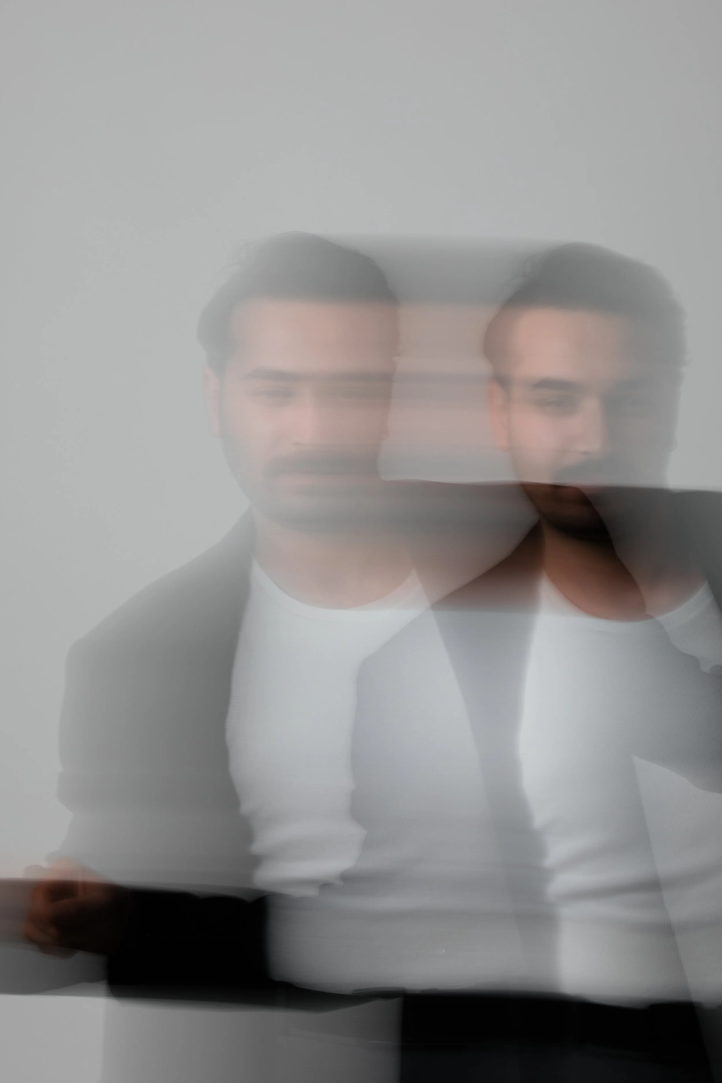 Abstract motion blur image of a man wearing a dark jacket and white shirt