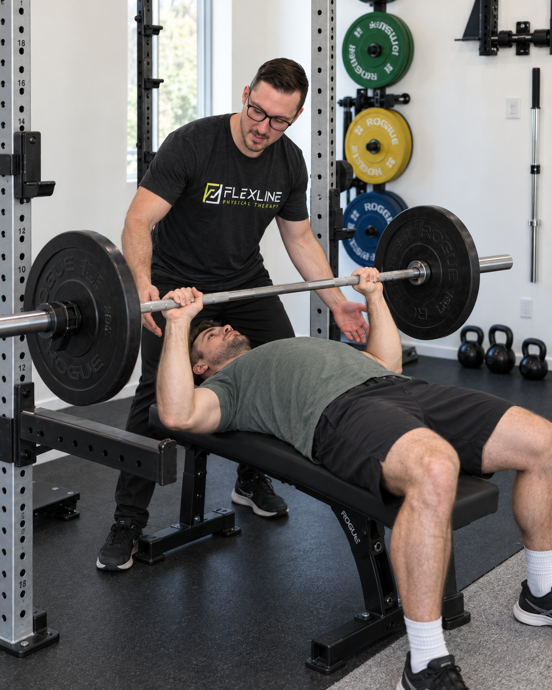 Physical therapist assessing bench press form to identify the cause of front shoulder pain during pressing
