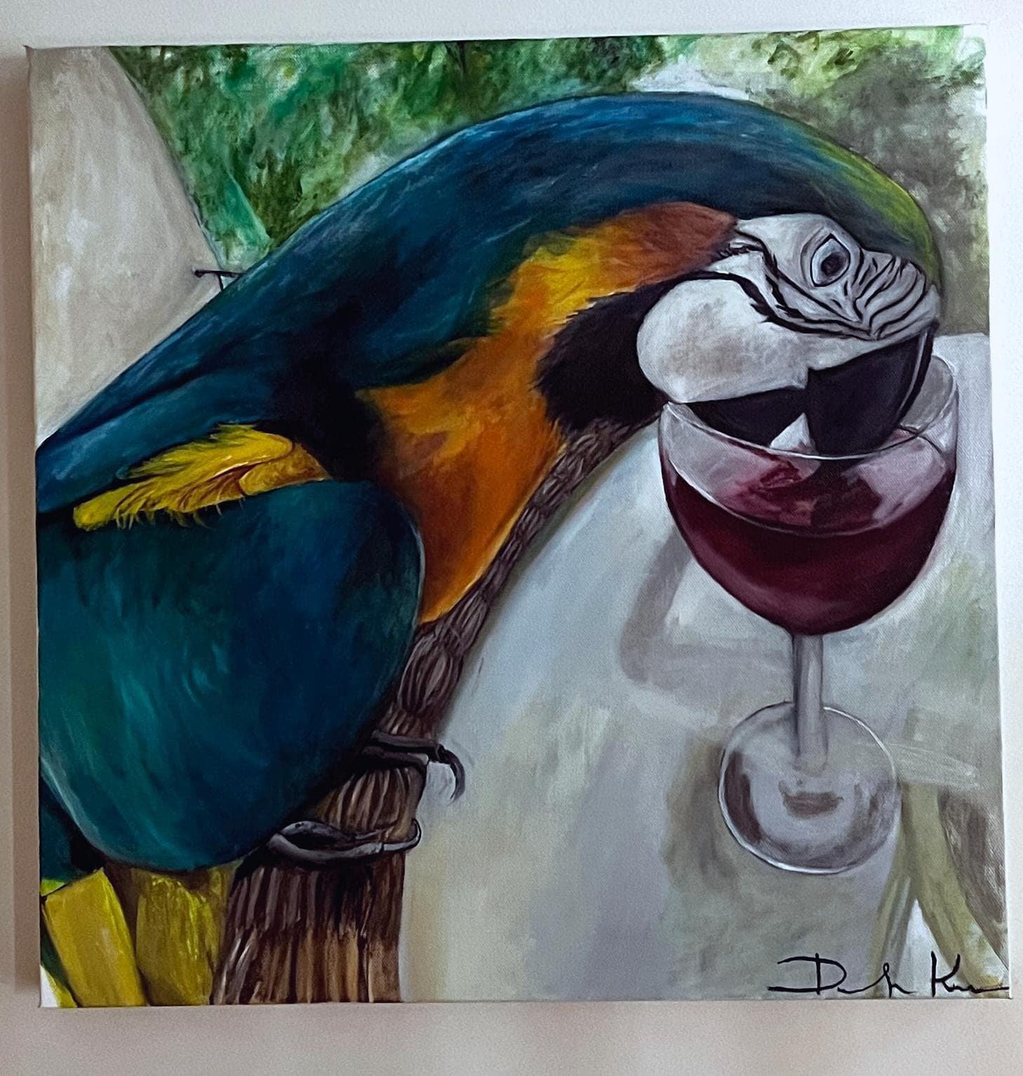 Painting of a colorful parrot leaning over a glass of red wine on a table with a neutral background and a signature in the bottom right corner.