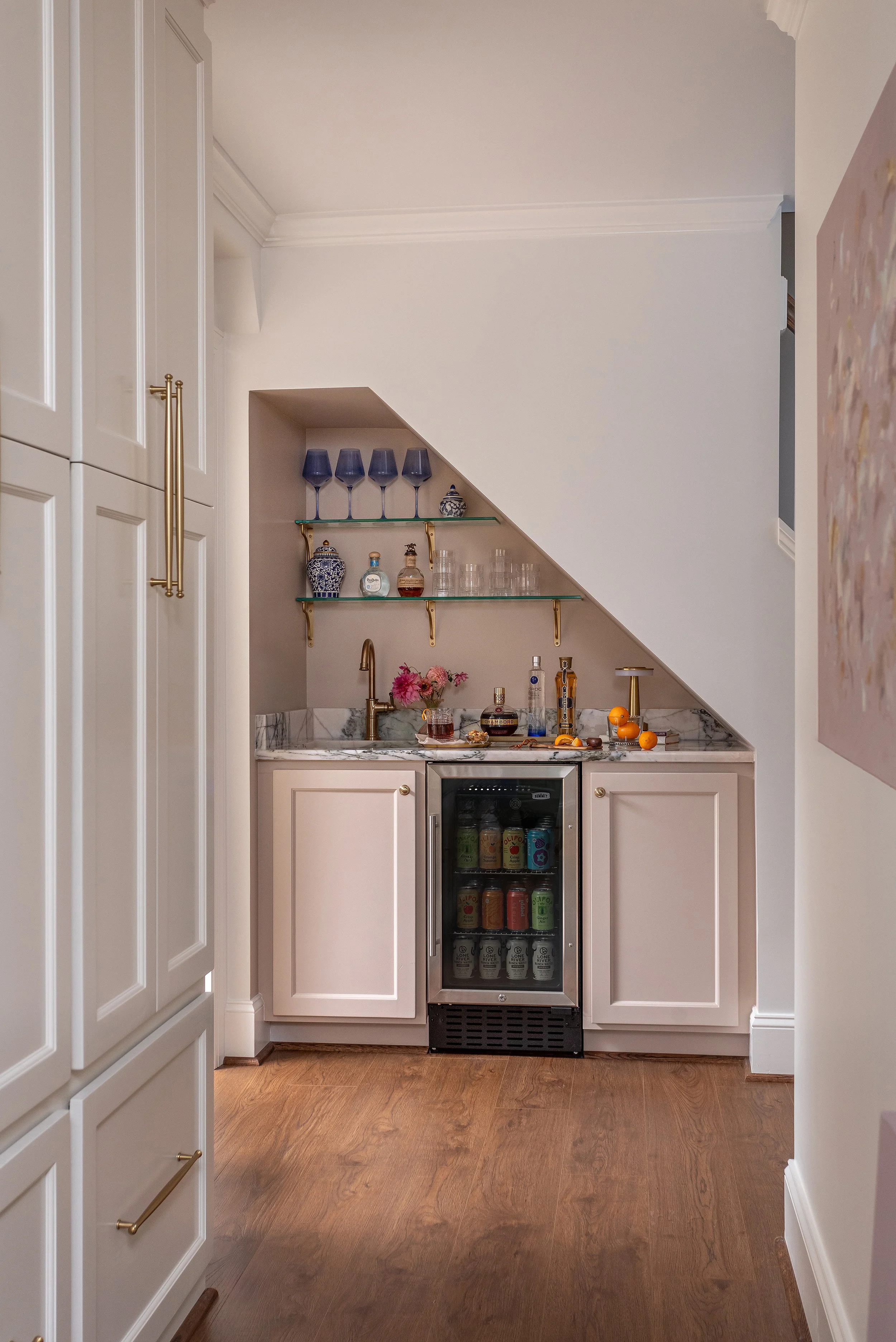 An under-stair wet bar that earns its keep with tailored cabinetry and warm blush tones 