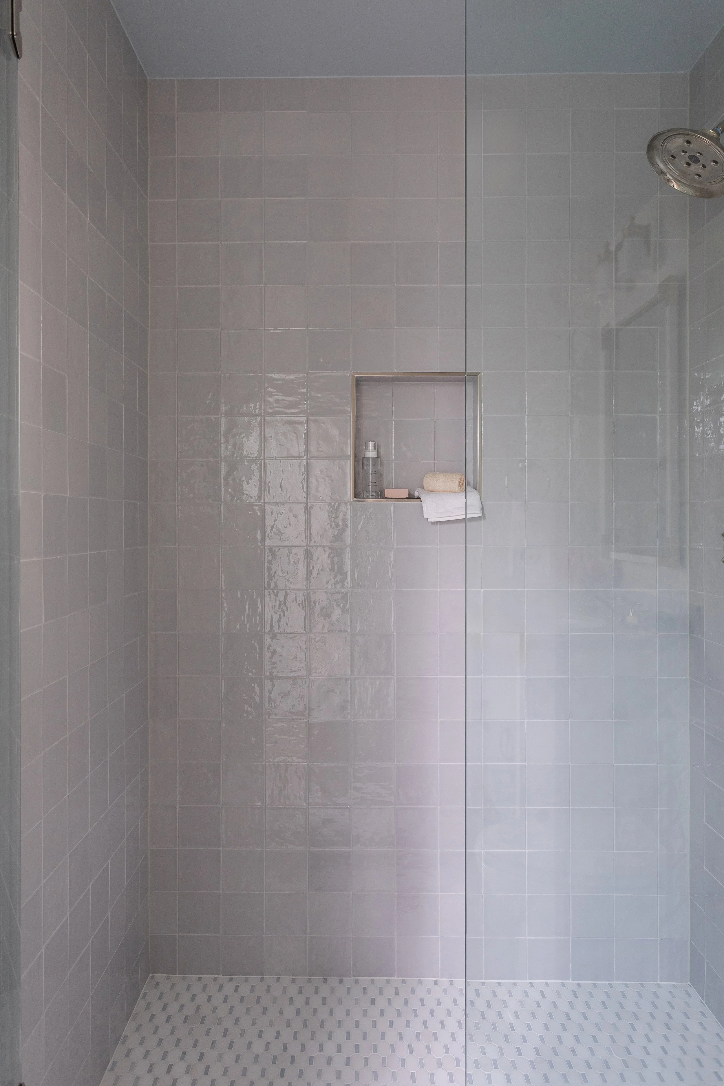Tiled walk-in shower in a neutral bonus room bathroom