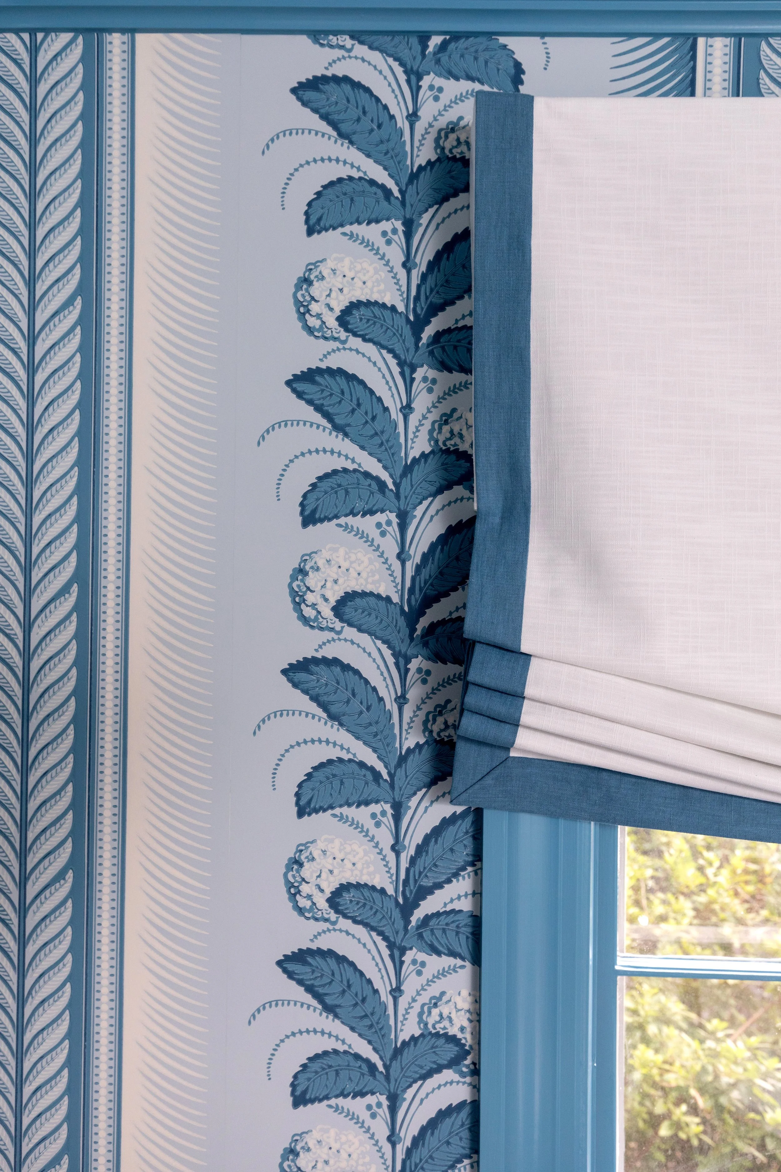 blue and white wallpaper and roman shade