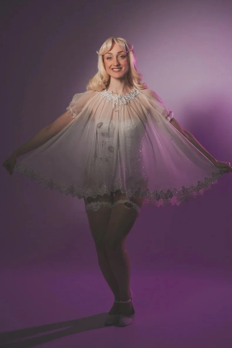 Top UK tribute act, 'The Sabrina Carpenter Tribute, a UK based tribute show to Sabrina Carpenter starring Heidi Gordon, in a professional photo wearing Sabrina's white rhinestoned catsuit and babydoll worn on the Short n' Sweet tour.