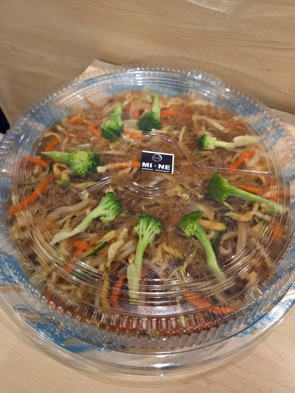 Container of stir-fried vegetables, including broccoli, carrots, and bean sprouts, from a Japanese restaurant.