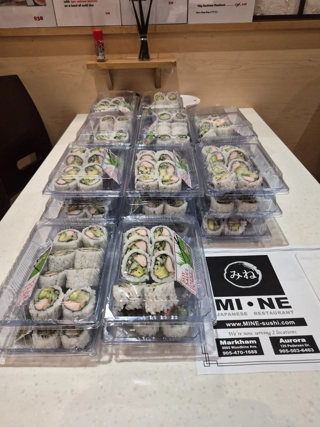 Multiple containers of sushi sets arranged on a table. School lunch catering for teachers and students. 