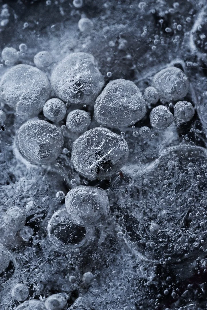 Close-up of bubbling icy water with air bubbles and ice crystals.