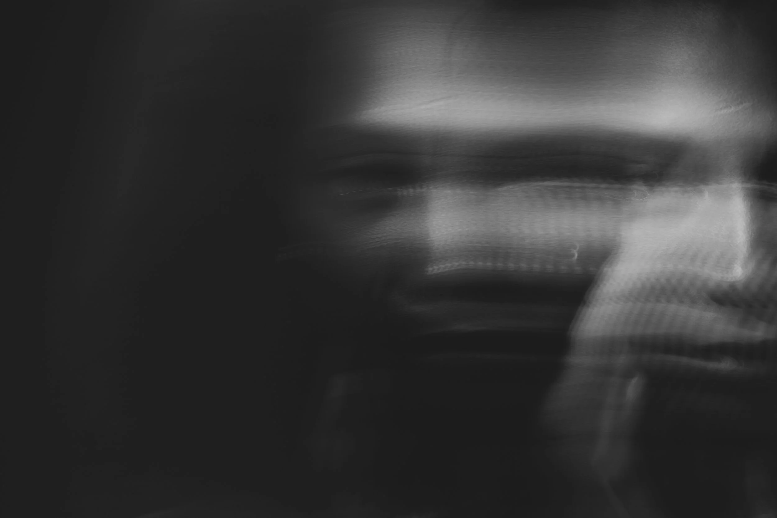 Black and white abstract image with blurred motion and layered textures.