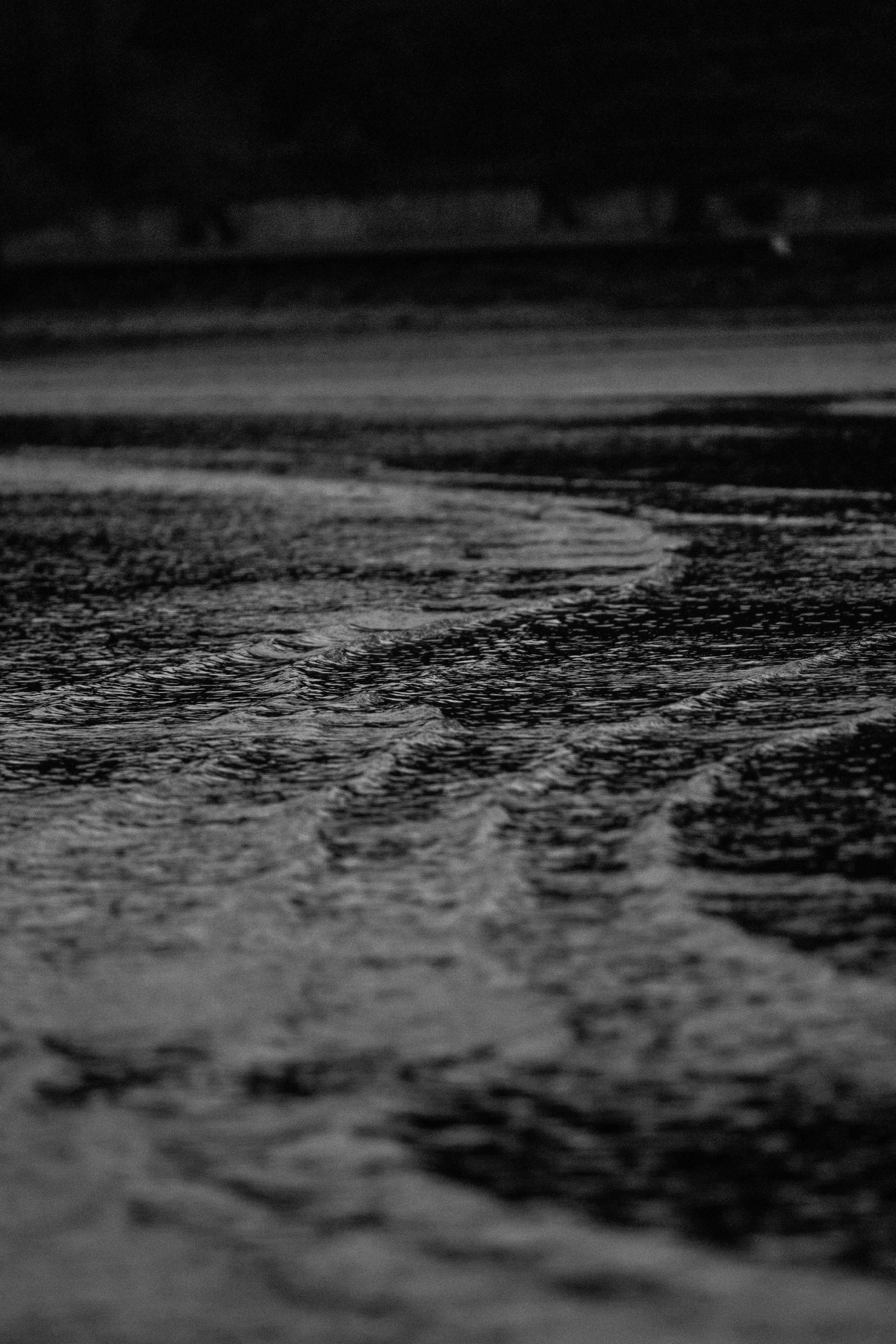Close-up of foamy ocean waves on a dark shore at night